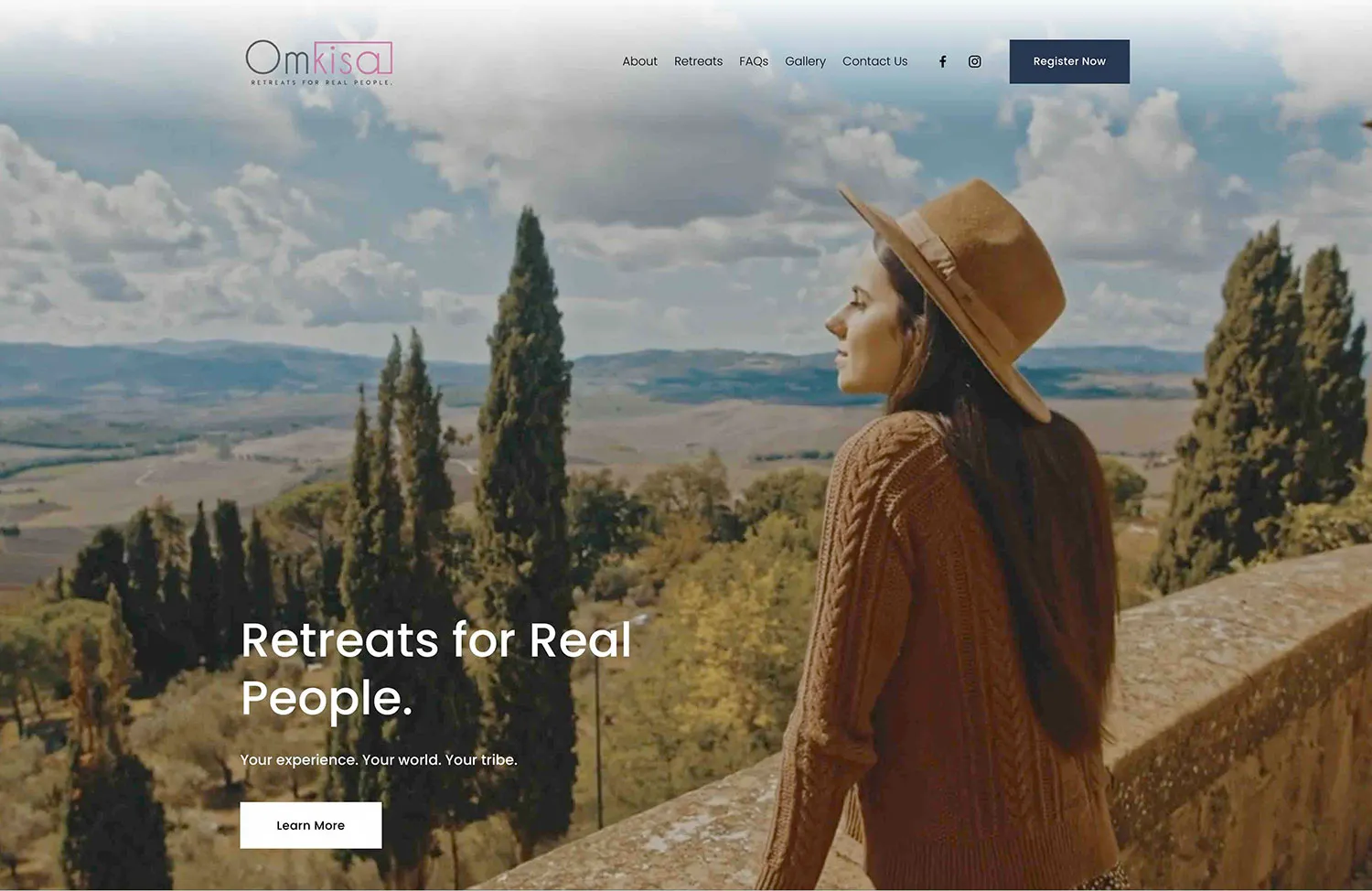 Omkisa homepage hero: Retreats for Real People, a woman in a hat overlooking Tuscan hills